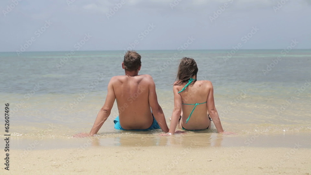 Young couple on vacations sitting and relaxing in the sea Young couple on vacations sitting and relaxing in the sea