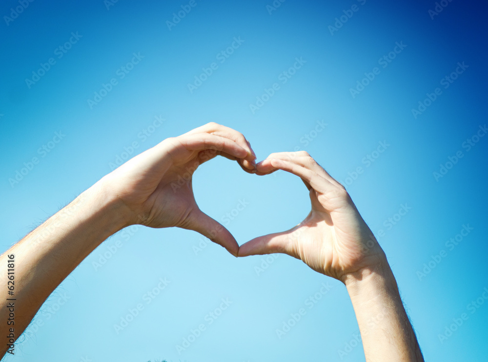 Hand heart shape against blue sky Hand heart shape against blue sky