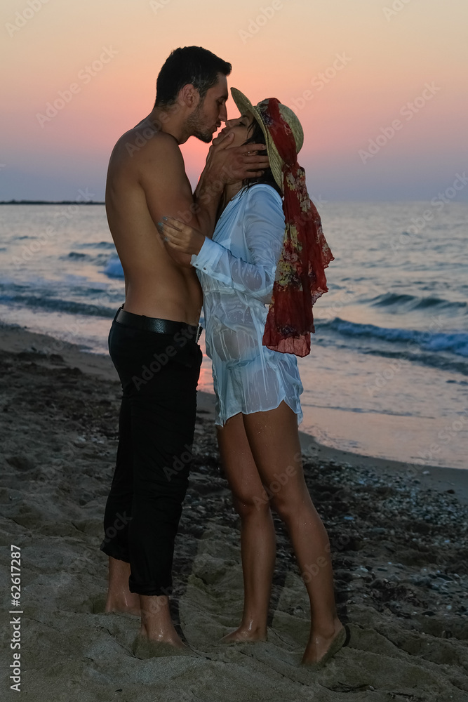 Happy young couple kissing at the beach at dusk. Happy young couple kissing at the beach at dusk.