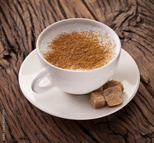 Cup of cappuccino with ground cinnamon.