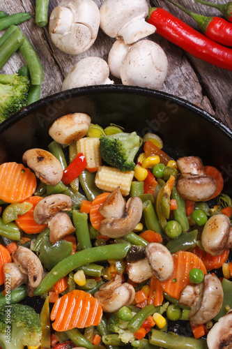 fried mushrooms with vegetables in a pan vertical
