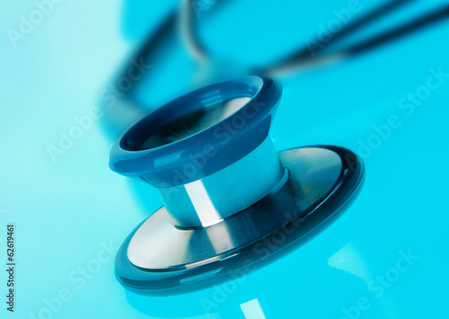 Stethoscope on blue, reflective background