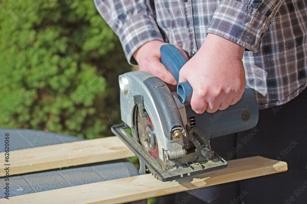 Man is working with electric circular saw Man is working with electric circular saw