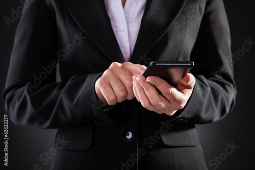 Businessperson Holding Black Cellphone Over Black Background