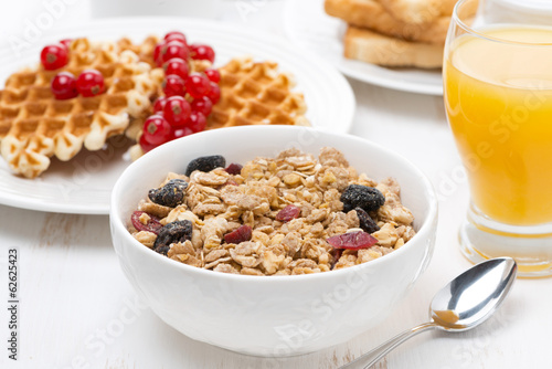 muesli, waffles with berries and orange juice for breakfast © cook_inspire