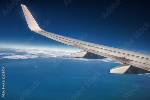 airplane wing in the sky and the horizon over the ocean