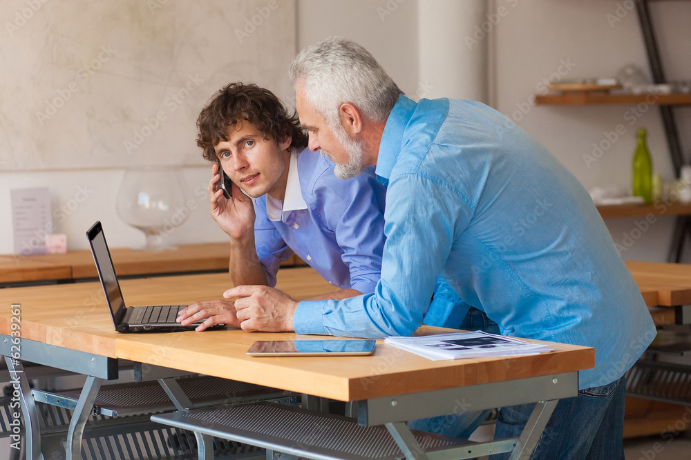 business man working on laptop with Colleges indoor business man working on laptop with Colleges indoor