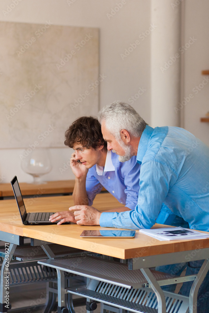 business man working on laptop with Colleges indoor business man working on laptop with Colleges indoor