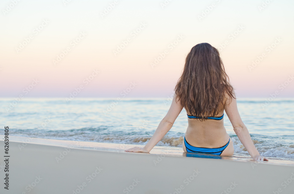 Woman on the beach at sunset.