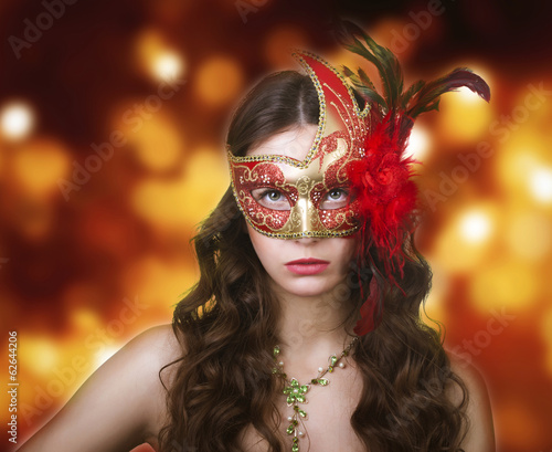 Woman in masquerade mask on a festive background.