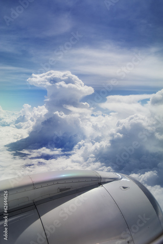 View of jet plane wing with giant cloud