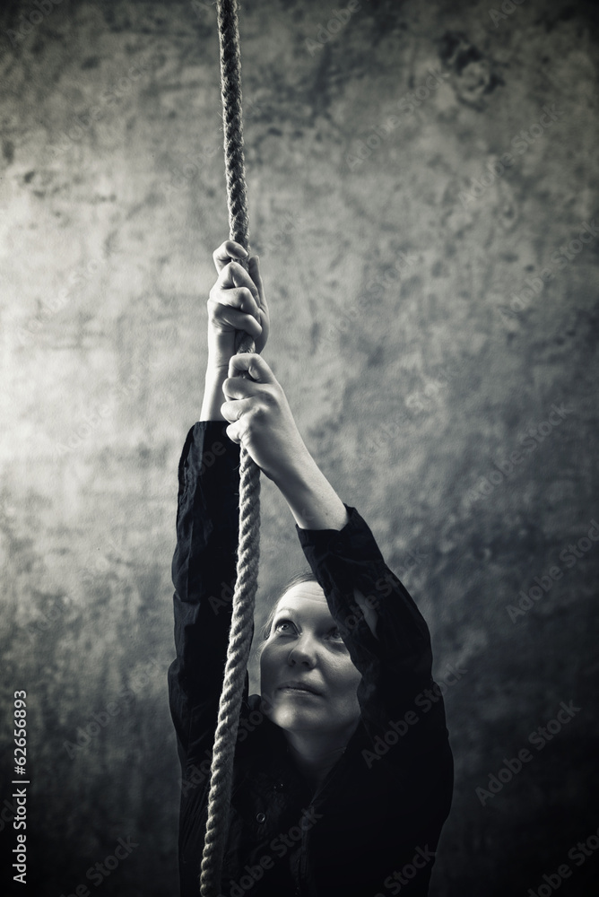 Woman climbing up with rope