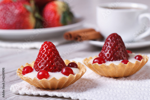 two tartlets with strawberries, cranberries and cream photo