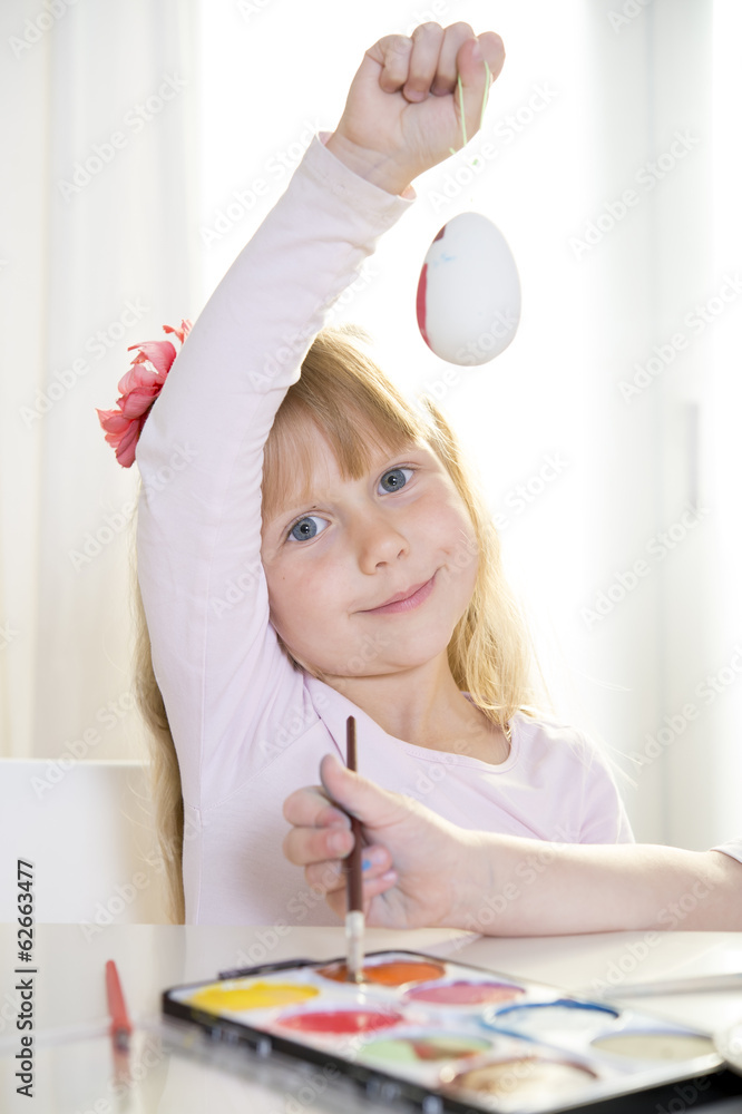 happy blonded girl painting a easter egg happy blonded girl painting a easter egg