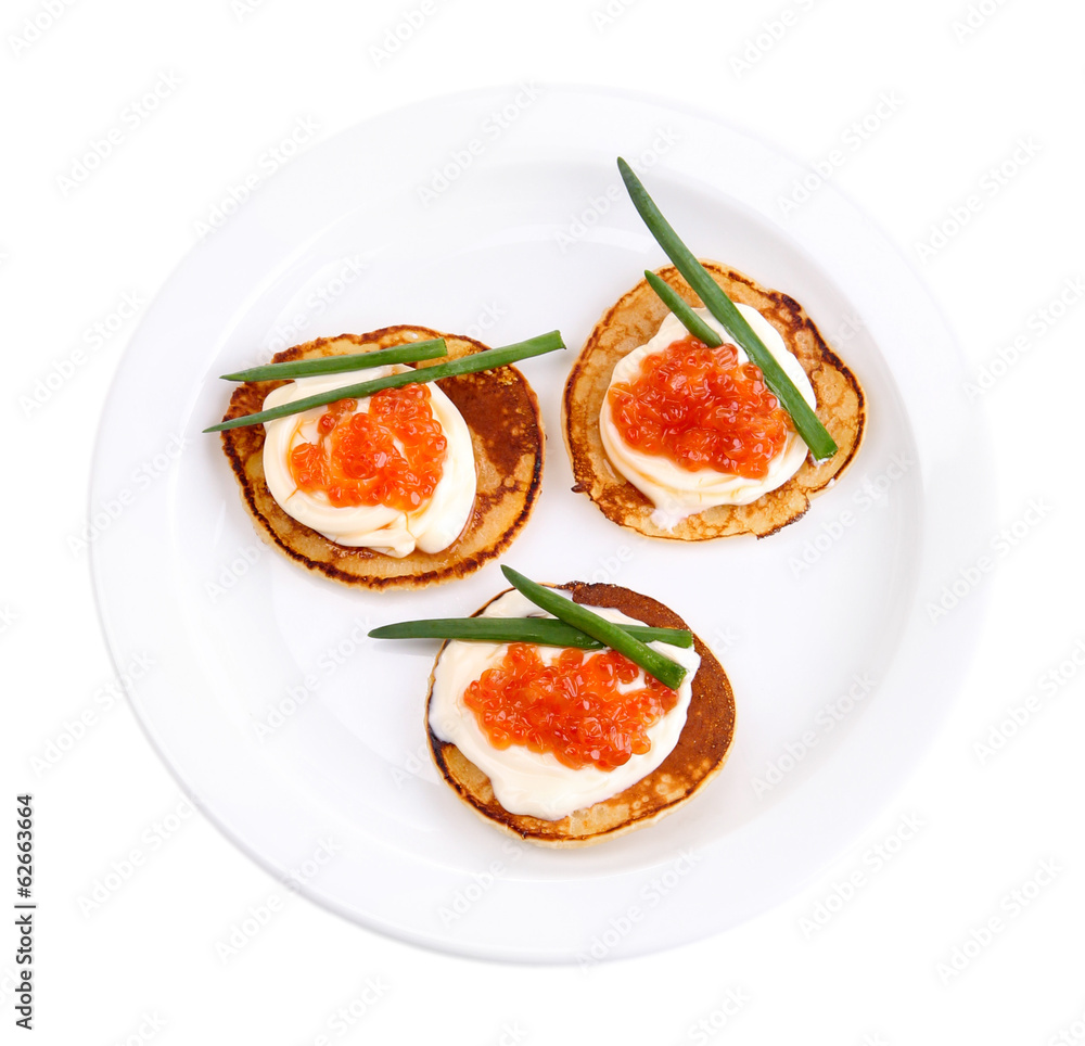 Pancakes with red caviar on plate, isolated on white