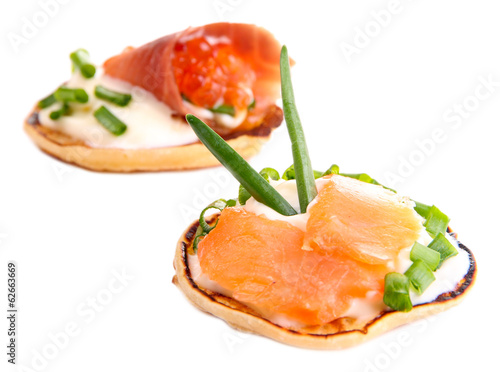 Pancakes with red caviar and salmon, isolated on white