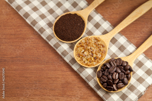 coffee beans and sugar in wooden spoon