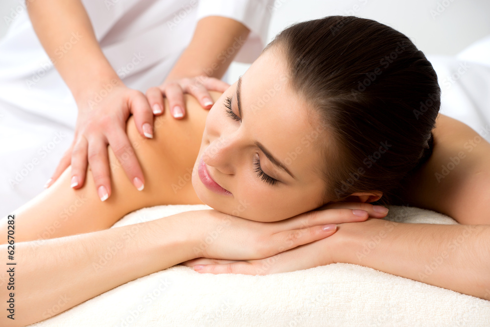 Masseur doing massage on the back of woman in the spa salon.