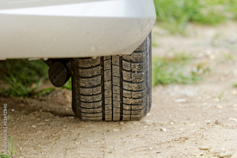 Car wheels on a dusty road detail