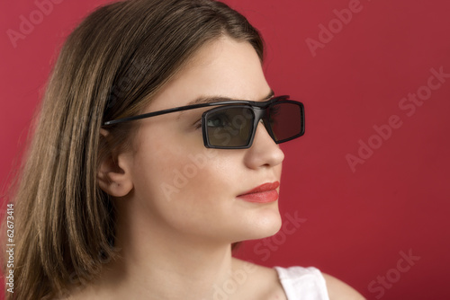 beautiful girl playing 3D video game isolated on red background