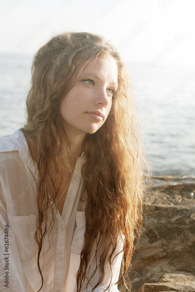portrait of a beautiful young woman with long hair in the sunlig