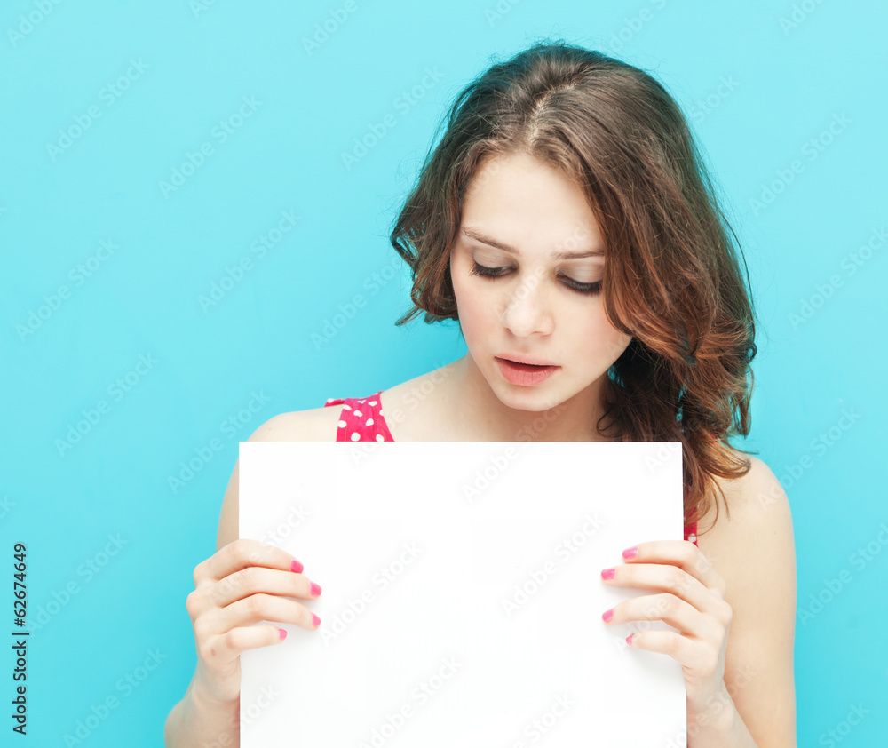 beautiful girl with a white sheet of paper on a blue background beautiful girl with a white sheet of paper on a blue background