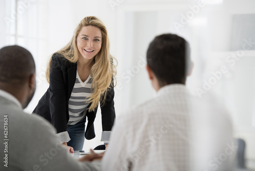 Wallpaper Mural Office Interior. A Woman Leaning On A Tabletop Talking To Two Men. Torontodigital.ca