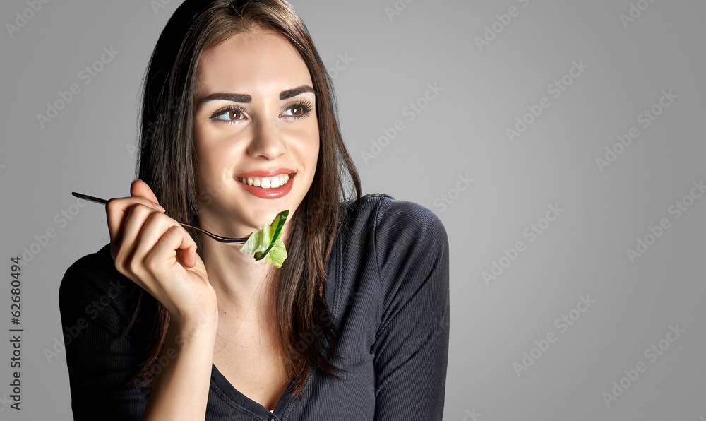 Young woman eating salad