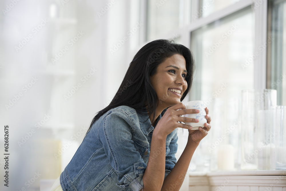 A Young Woman Wearing A Denim Shirt, Holding A China Cup. A Young Woman Wearing A Denim Shirt, Holding A China Cup.