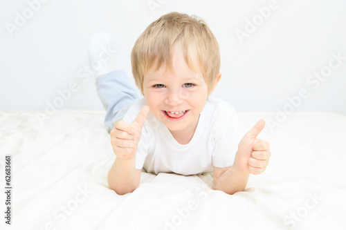 happy little boy with thumbs up on white