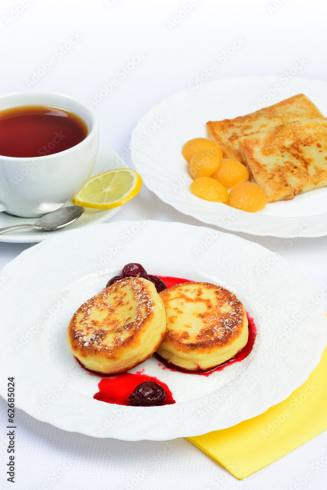 Food of Crepes, cheesecakes with berry sause and cup of tee. Food of Crepes, cheesecakes with berry sause and cup of tee.