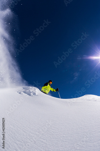 Alpine skier with freeze motion of powder snow