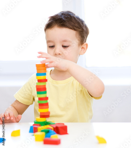 Boy is playing with building blocks