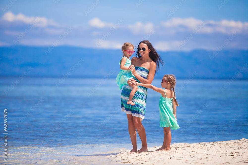Adorable little girls and young mother have fun on tropical Adorable little girls and young mother have fun on tropical