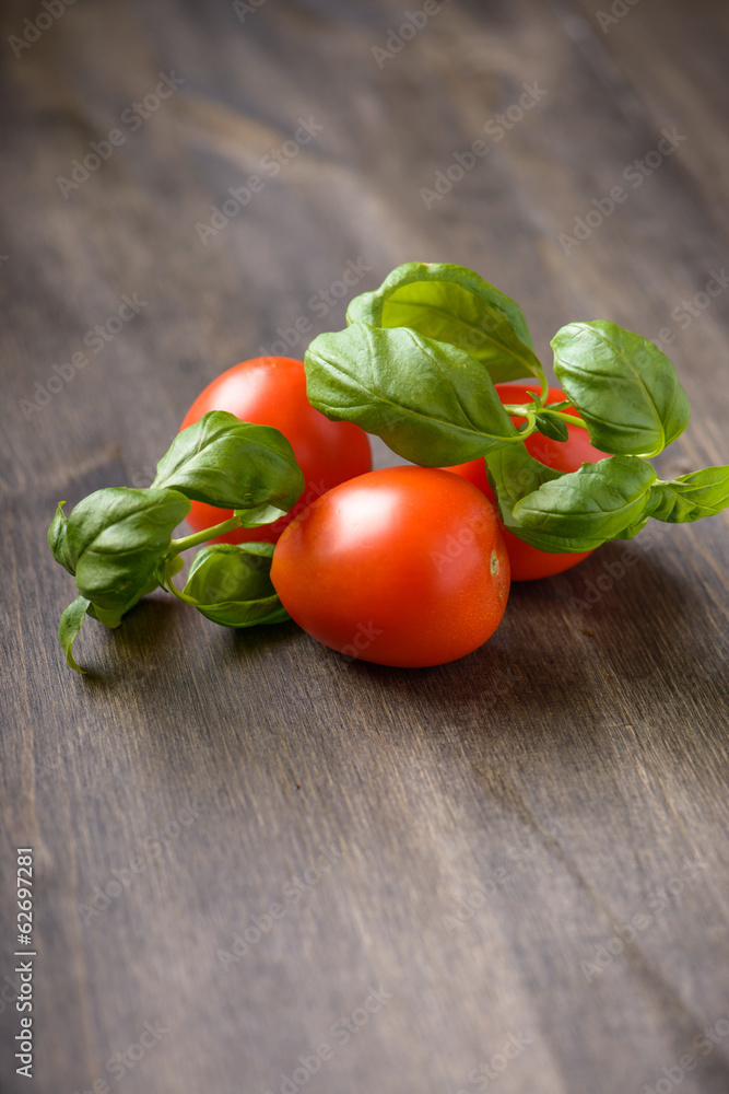 Tomatoes and basil on a wood table Tomatoes and basil on a wood table