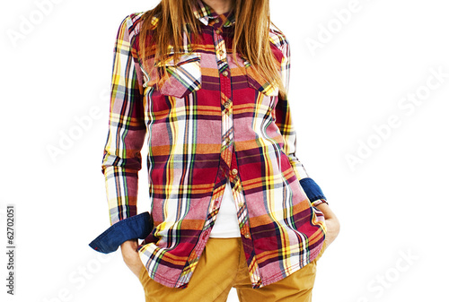 Young fashion woman in plaid shirt and hands in pockets