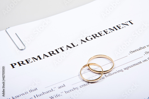 Prenuptial Agreement form and two gold wedding rings photo