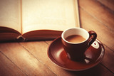 brown cup of the coffee and vintage book.