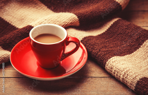 Red cup of the coffee and vintage scarf. photo