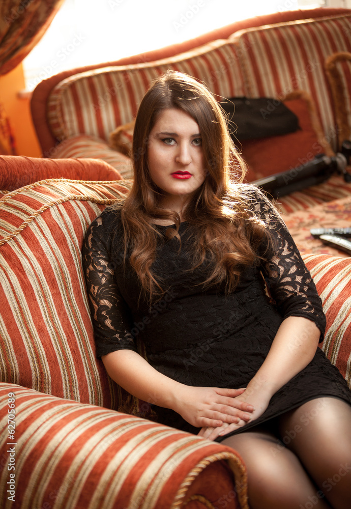 Portrait of sexy brunette woman sitting on luxurious chair Portrait of sexy brunette woman sitting on luxurious chair