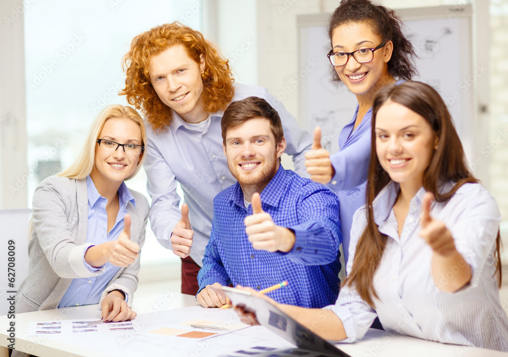creative team with papers showing thumbs up creative team with papers showing thumbs up