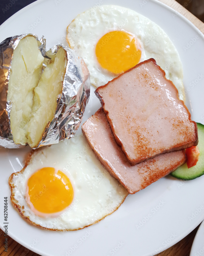 Traditional german dish with meat,fried egg and baked potato Traditional german dish with meat,fried egg and baked potato