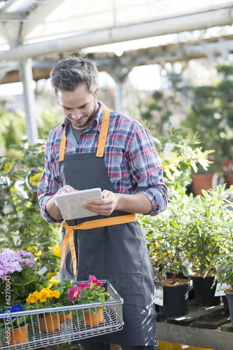 Professional gardener using a digital tablet in a garden center