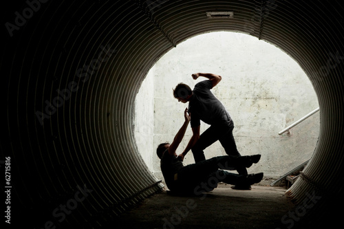 Foto Young man being mugged in a dark tunnel