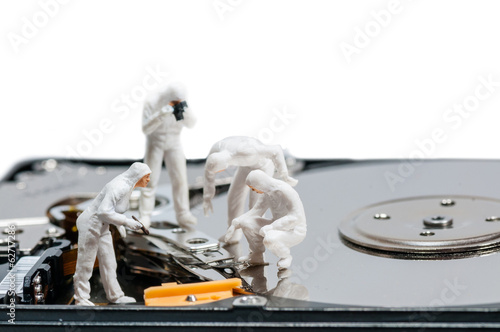 Canvas Print Group of criminologists inspecting broken hard rive