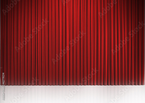 Red closed curtain with light spots in a theater