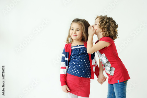 Two cute little girls talking on a white background.