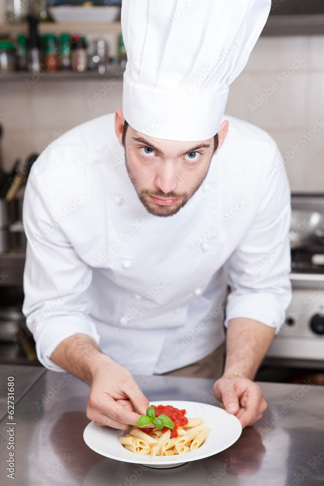 Male chef completing pasta..