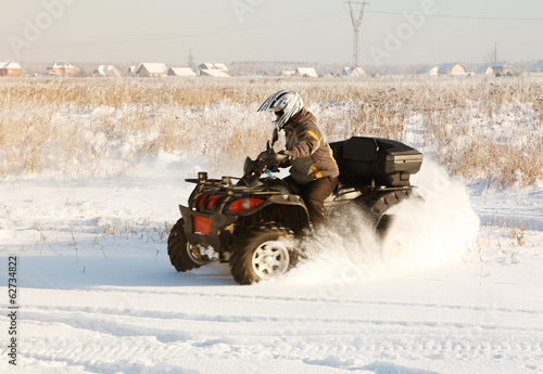 terrain vehicle in motion at winter sunny day photo