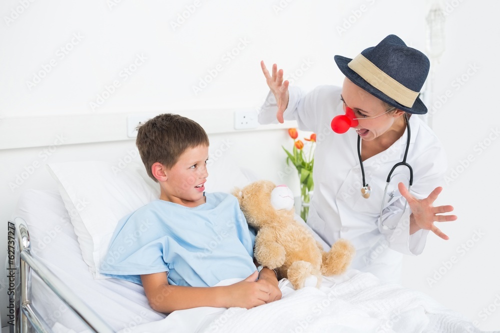 Doctor in clown costume entertaining ill boy in hospital Doctor in clown costume entertaining ill boy in hospital